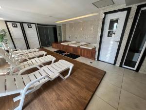 ein Raum mit weißen Loungesesseln und ein Raum mit Türen in der Unterkunft Hotel Vila Catavento in Petrolina