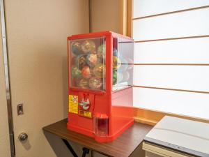 Ein roter Kühlschrank steht auf einem Tisch. in der Unterkunft Shinsaibashi ARTY Inn in Osaka