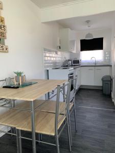Una cocina con una mesa y sillas de madera. en Bulldog holidays 243, en Hemsby