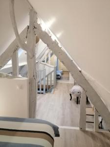 a attic room with a bed and a staircase at Gîte Les Mirabelles Calme et Reposant in Vieux-Pont-En-Auge
