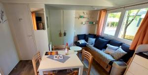a small living room with a couch and a table at Mobil Home Camping Les VIVIERS, Claouey in Claouey