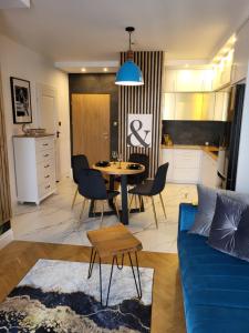 - un salon avec un canapé bleu et une table dans l'établissement Apartament SixtySix 66 z kominkiem, à Białystok