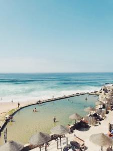 un grupo de personas nadando en una piscina en la playa en Azenhas do Mar Roadside House en Colares