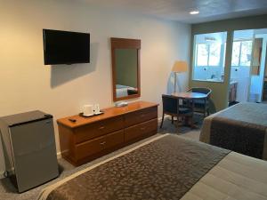 a hotel room with a bed and a dresser and a mirror at Murphey's Motel LLC in Lee Vining +26 photos