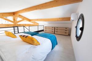 - une chambre avec un grand lit dans une pièce dotée de plafonds en bois dans l'établissement Maison Réglisse du MAS LOU CAPY, à Salon-de-Provence