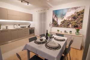 Una cocina y un comedor con mesa y sillas. en Luxury apartment Vela with swimming pool, en Premantura
