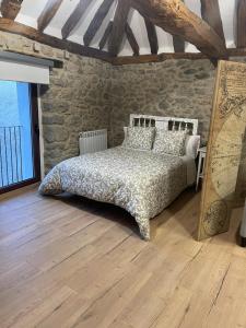 - une chambre avec un lit et un mur en pierre dans l'établissement Loft Casa Bergua, à Arguis