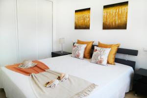 a bedroom with a white bed with two dolls on it at Terras Novas Village Albufeira in Albufeira +19 photos