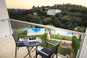 uma varanda com mesa e cadeiras e uma piscina em Terras Novas Village Albufeira em Albufeira