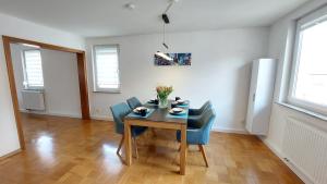 a dining room with a table and blue chairs at FeelHome Ferienwohnung Tuttlingen in Tuttlingen