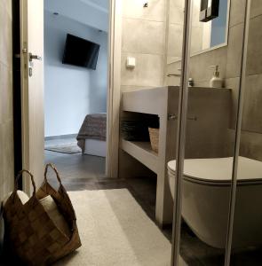 a bathroom with a toilet and a sink and a television at Aethrèa Apartments in Haraki