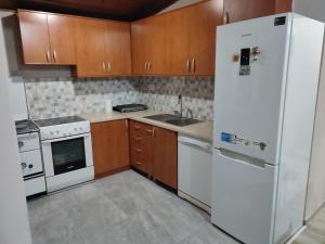 a kitchen with a white refrigerator and wooden cabinets at Liprosh in Virpazar