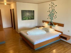 Motel Brunner Apartments & Zimmer في باد ايزينكابيل: غرفة نوم بسرير كبير في غرفة