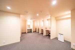 une pièce vide avec une rangée de chaises et de bureaux dans l'établissement Shinsaibashi ARTY Inn, à Osaka