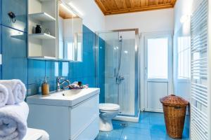 a blue bathroom with a sink and a toilet at Aegean View Villa in Skopelos Town +37 photos