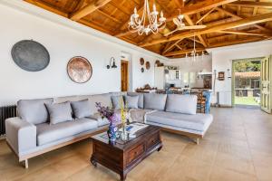 a living room with two couches and a table at Aegean View Villa - Sea View Family Sanctuary in Skopelos Town