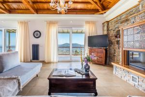 a living room with a couch and a tv at Aegean View Villa - Sea View Family Sanctuary in Skopelos Town +48 photos