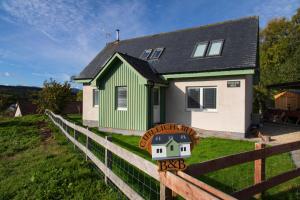 a green and white house with a fence at Cuillich Mill Bed and Breakfast in the Highlands in Alness