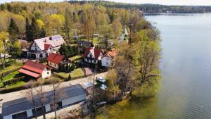 an aerial view of a house on the shore of a lake at Dom letniskowy Narie in Morąg