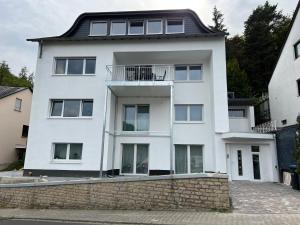 een wit huis met een zwart dak bij VonMos Loft Apartment in Bernkastel-Kues