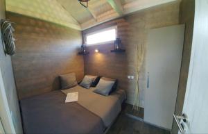 a small bed in a room with a window at House Kalmia in Fonyód