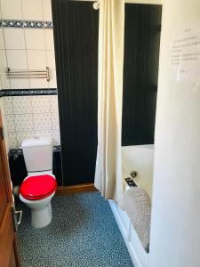 ein Badezimmer mit einem roten WC und einer Badewanne in der Unterkunft Cosy house, 3 bedrooms, private parking, wifi, patio in Norwich