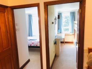 ノリッジにあるCosy house, 3 bedrooms, private parking, wifi, patioのベッドルーム1室(ベッド1台、鏡付)