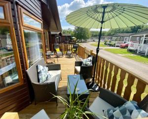 a patio with chairs and an umbrella on a deck at Dot's Place 1 in Carnforth