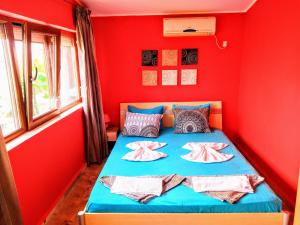 a bedroom with red walls and a blue bed at All inclusive luxury villa with sea view in Chernomorets