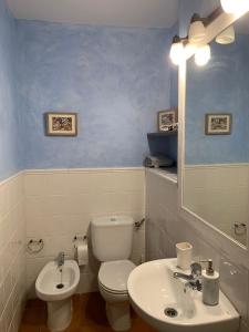 a bathroom with a white toilet and a sink at La Casa de Baix in Torre del Compte +13 photos