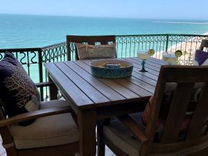 a wooden table on a balcony with a view of the ocean at Sonoran Sea Resort Oceanfront PENTHOUSE in Puerto Peñasco