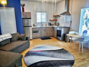 a living room with a couch and a kitchen at LuxQuarters Kitimat River Suite in Kitimat