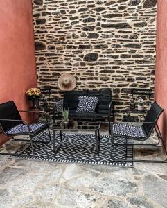 two chairs and a table in front of a stone wall at LA MAISON DU PORT in Plérin