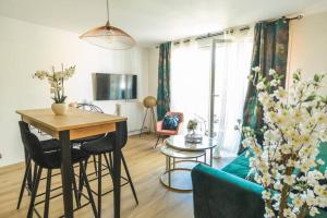 uma sala de estar com mesa e cadeiras em Bien chez soi à Evry appt 53m2 balcon parking em Évry-les-Châteaux