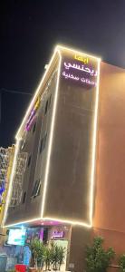 a building with a neon sign on the side of it at أبها ريجنسي in Abha