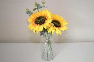 a vase filled with yellow flowers on a table at Ruby Retreat - Entire House - WiFi - 4 Bed - Garden - Maidstone Town in Maidstone