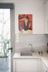 una cucina con un lavandino e un quadro sul muro di Stylish living by Acropolis (Monastiraki 5) ad Atene
