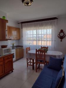 a kitchen with a table and chairs and a kitchen with a table and a kitchen at Apartamento en San Vicente de O Grove in O Grove