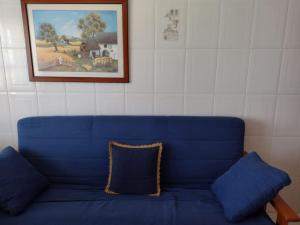 a blue couch with a pillow on top of it at Apartamento en San Vicente de O Grove in O Grove