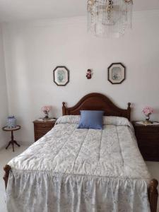 a bedroom with a bed with a blue pillow on it at Apartamento en San Vicente de O Grove in O Grove