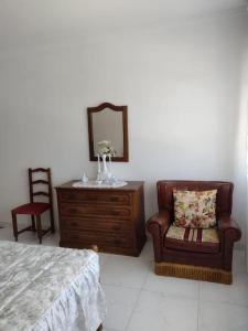 a bedroom with a dresser and a chair and a mirror at Apartamento en San Vicente de O Grove in O Grove