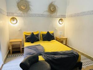 een slaapkamer met een geel bed en 2 tafels bij Riad La Residenza in Marrakesh