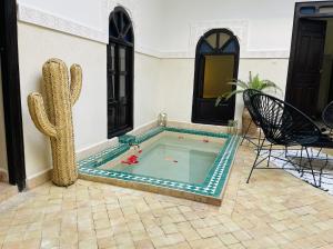 una piscina en una casa con un cactus en Riad La Residenza, en Marrakech