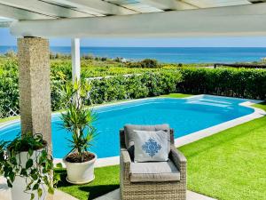 a patio with a chair and a swimming pool at Villa Adel in San Teodoro