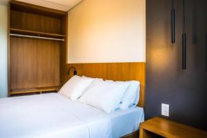 Bett mit weißen Kissen in einem Zimmer in der Unterkunft Salinas Premium Resort in Salinópolis