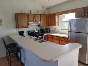 a kitchen with a white counter top and a refrigerator at Melbourne Beach Florida Townhouse ocean front 1.2 acre property in Melbourne Beach