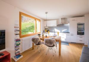 een keuken en eetkamer met een tafel en stoelen bij Chalet Monchsbuffel in Wengen