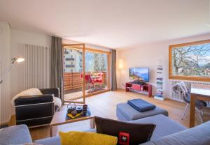 een woonkamer met 2 banken en een televisie bij Chalet Monchsbuffel in Wengen