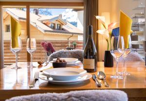 een tafel met een bord eten en een fles wijn bij Chalet Monchsbuffel in Wengen +17 foto's