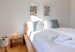 een slaapkamer met een wit bed met blauwe en witte kussens bij Chalet Monchsbuffel in Wengen